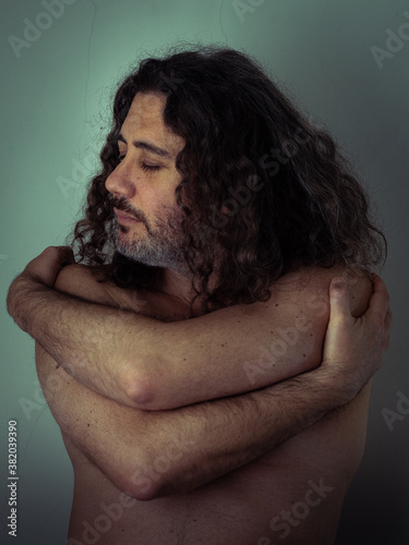 hombre de pelo largo y barba en cuero se abraza cariñosamente photo
