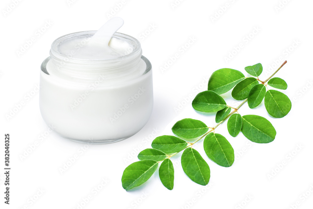 Moringa beauty cosmetic cream lotion in glass jar and green moringa Oleifera leaf ( Horse radish or Drumstick )  isolated on white background . Skincare, beauty and spa concept. 
