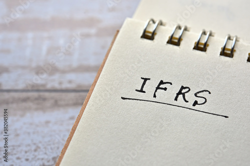 At the edge of the notebook, "IFRS" is written. Close-up.