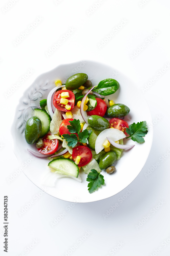 Healthy Salad with Feta Cheese, Green Olives, Baby Spinach, Cucumber, Cherry Tomatoes and Capers. Bright background. Top view. Close up. Healthy Salad with Feta Cheese, Green Olives, Baby Spinach, Cucumber, Cherry Tomatoes and Capers. Bright background. Top view. Close up.