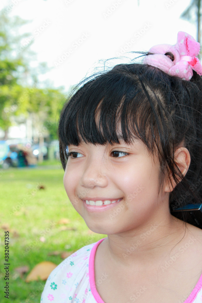 Asian young girl with pink bow smiling Asian young girl with pink bow smiling