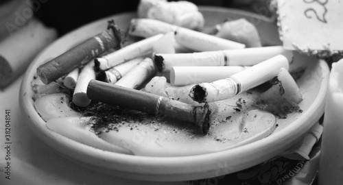 Fotografia end fag , butt cigarette , ashtray grunge background in black and white