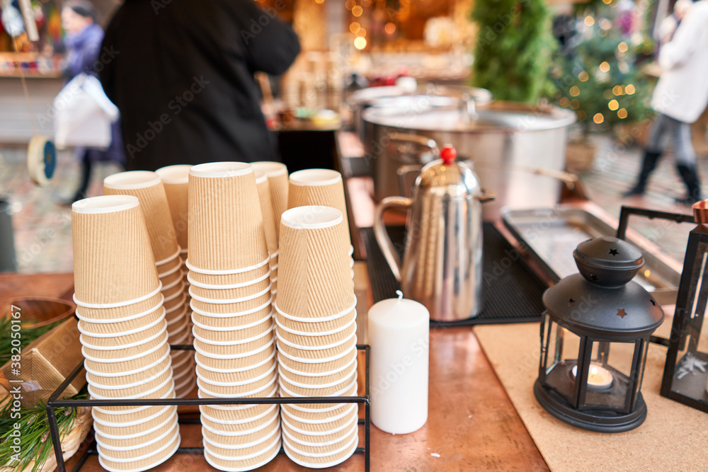 Mulled wine in Christmas market. Paper cups for Christmas mulled wine in old town Small European City. Mulled wine in Christmas market. Paper cups for Christmas mulled wine in old town Small European City.