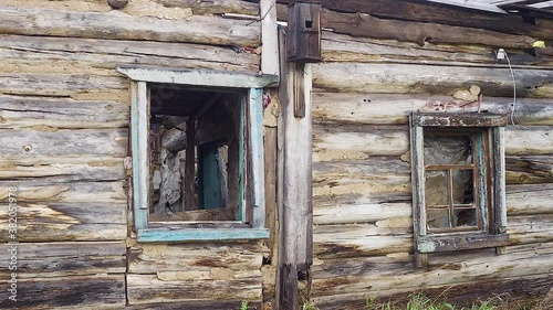  Fragment of an old abandoned house with a window and bird house