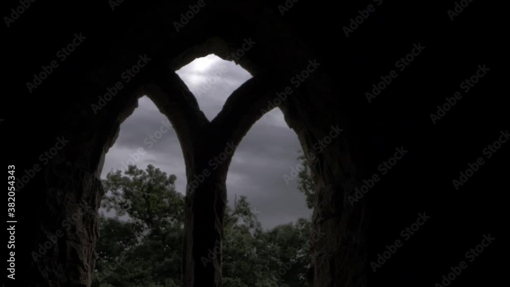 Arched windows on old building with gloomy cloudy skies panning shot Arched windows on old building with gloomy cloudy skies panning shot