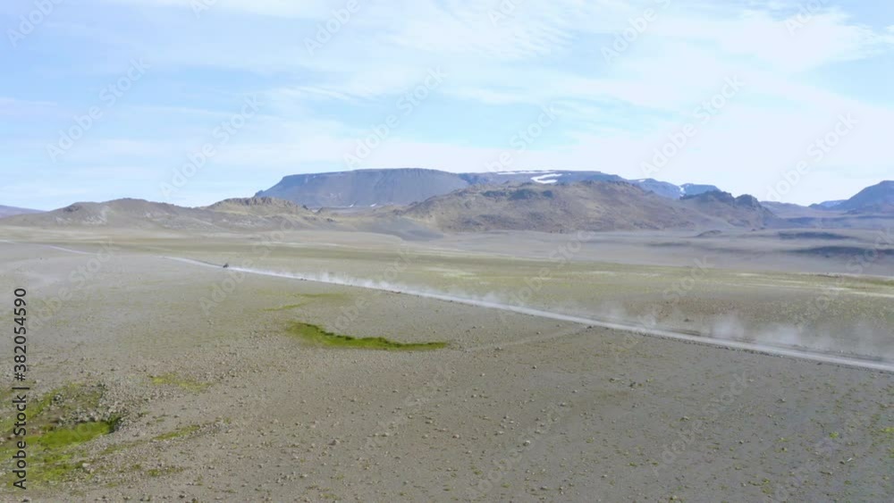 Birds eye view of a buggy car 4x4 driving on vast endless barren land and heading towards Icelandic glacier. Birds eye view of a buggy car 4x4 driving on vast endless barren land and heading towards Icelandic glacier.