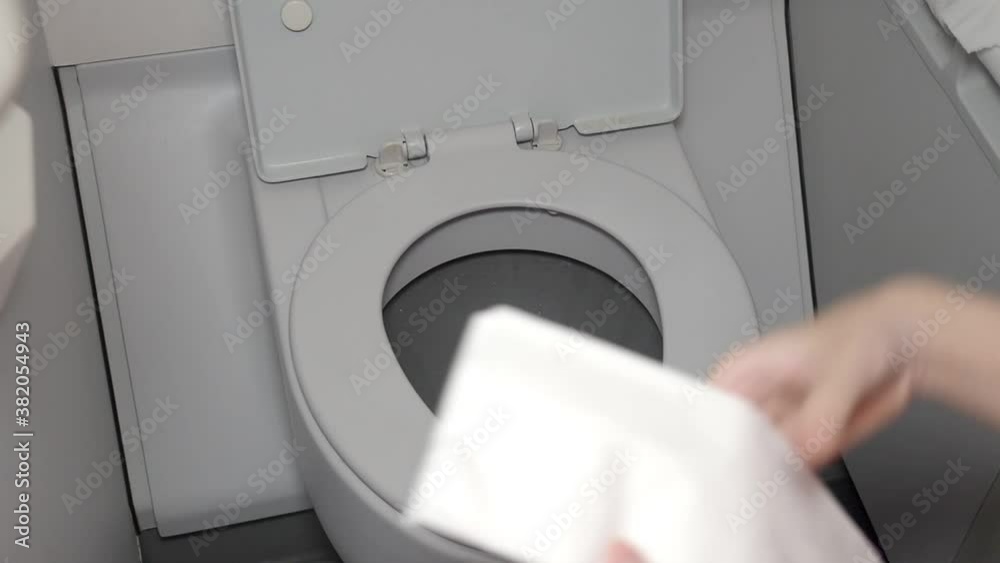 close up female hand wiping aircraft lavatory toilet bowl, cleaning habit, bacteria on airplane restroom door, corona virus covid19, public health concern, concept, disinfectant wipes, illness spread close up female hand wiping aircraft lavatory toilet bowl, cleaning habit, bacteria on airplane restroom door, corona virus covid19, public health concern, concept, disinfectant wipes, illness spread