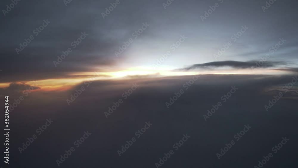 aerial view of sunset from aircraft window seat. broken cloud overcast the terrain. aerial view of sunset from aircraft window seat. broken cloud overcast the terrain.