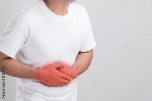 Wallpaper Mural Liver or kidney problem concept : Man holding hand on belly and feeling a pain in liver or . Studio shot isolated on grey background with copy space for text Torontodigital.ca