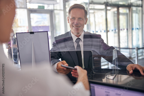 Joyful businessman during registration procedures at airport
