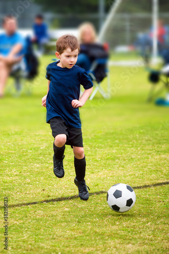 Fototapeta Naklejka Na Ścianę i Meble -  Happy young boy playing organized soccer