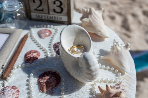 Obraz na plátně Close up view of wedding rings in the white ceramic shell on the table with wedd
