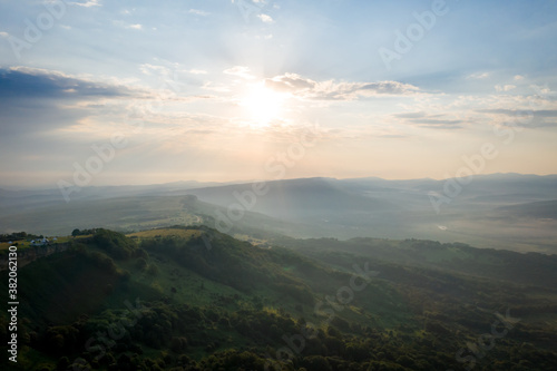 Early morning in the mountains. Morning sun and haze in the valley against the background of mountains. Mountain summer landscape © Alexey Oblov