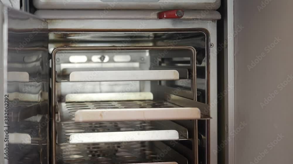 female cabin crew hand open oven and insert hot meal aluminum box for