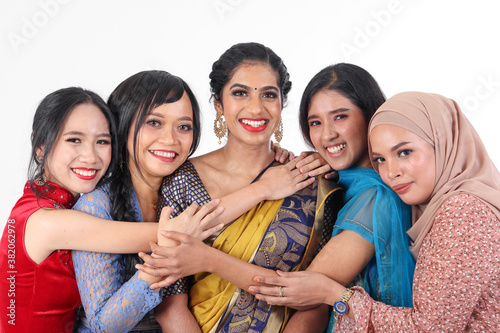 South east Asian Malay Chinese Indian race ethnic origin woman wearing dress costume baju kurung cheongsam samfu kebaya Sharee multiracial community on white background happy smile hug togetherness photo