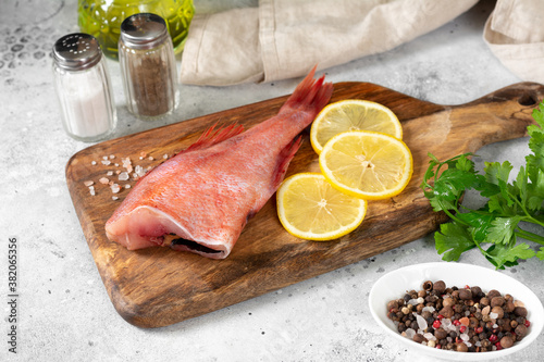 Grouper. Sea bass on a wooden Board on a light gray kitchen table. Raw sea bass closeup 