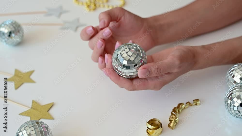 Female hands hold small mirror ball. Preparing decorations for the Christmas tree or New Year's Eve. Female hands hold small mirror ball. Preparing decorations for the Christmas tree or New Year's Eve.