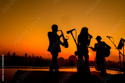 Silhouette twilight scene of trio musician background.