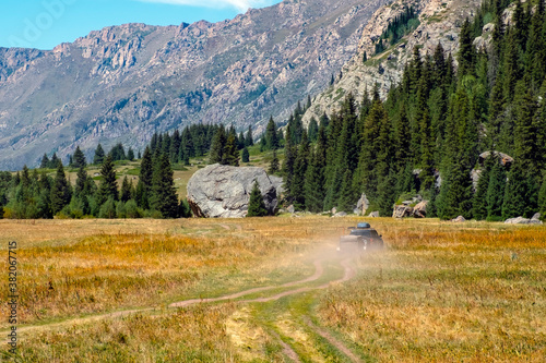 Offroad car is riding on gravel road. Overlanding concept. Kora river gorge in Kazakhstan, way to Burkhan bulak waterfall. Tourism in Kazakhstan concept.