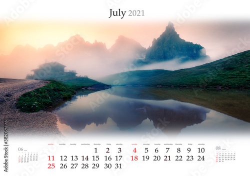 Calendar July 2021, B3 size. Set of calendars with amazing landscapes. Foggy morning view of Baita Segantini mountain refuge with Cimon della Pala peak. Summer sunrise in Dolomiti Alps, Italy
