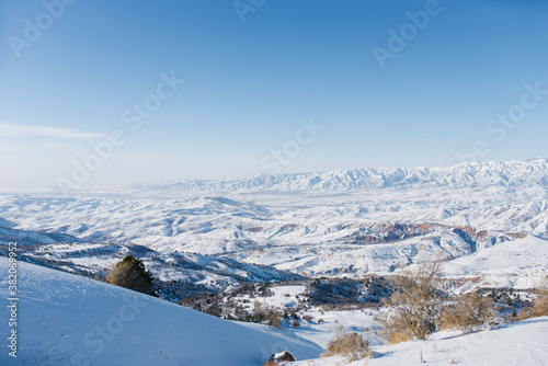 Picturesque Tien Shan mountains in Uzbekistan, covered with snow, winter clear Sunny day in the mountains. Amazing panorama in Beldersay photo