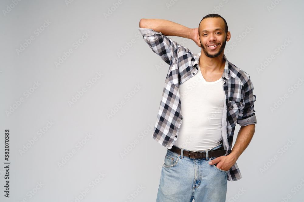 african-american young man wearing casual shirt over light grey background african-american young man wearing casual shirt over light grey background