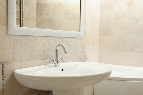 Sink in modern comfortable bathroom in light beige color