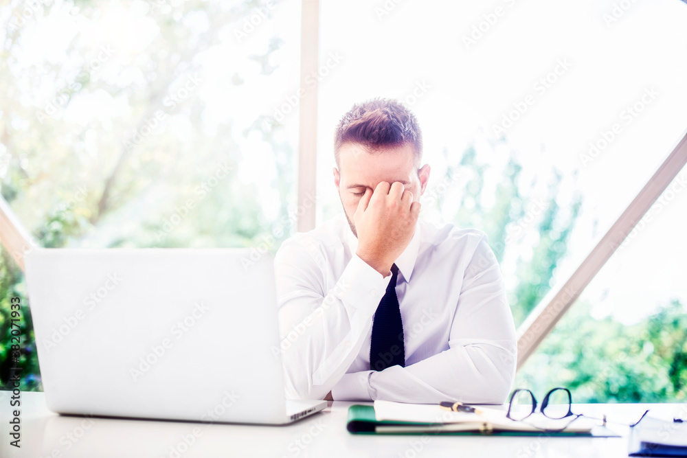 © sepy - Frustrated businessman having a headache while working on laptop at office desk © sepy - Frustrated businessman having a headache while working on laptop at office desk