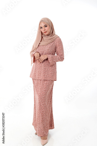 South east Asian Malay race ethnic origin woman wearing dress costume baju kurung tuding headscarf on white background photo