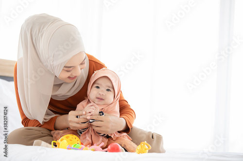 Photography A Muslim mother and  toddler are indoors in their bedroom