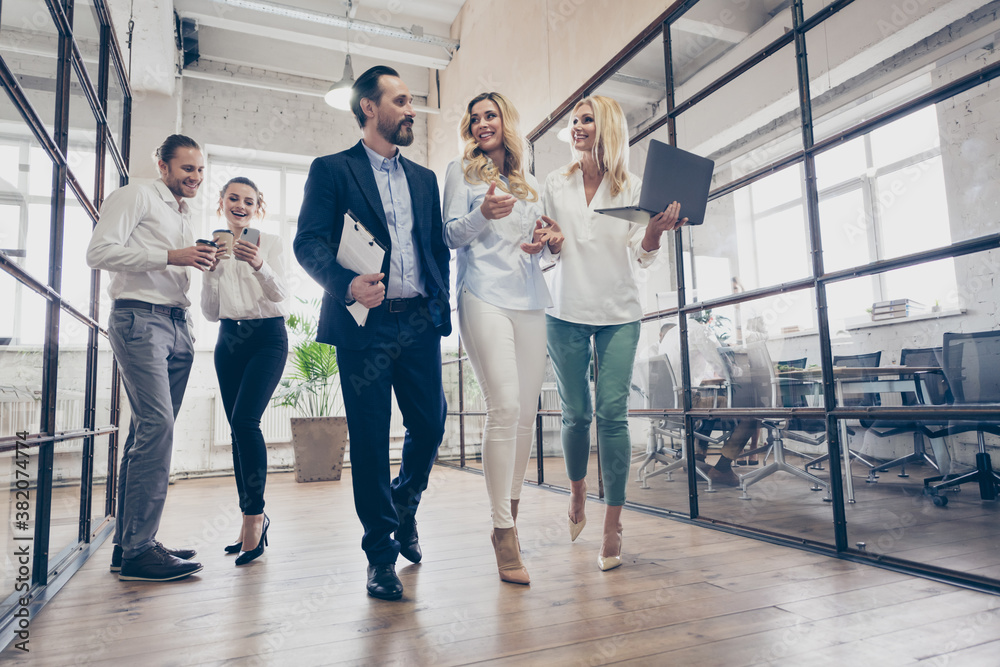 Fototapeta premium Low angle view full length photo of two woman go walk hold laptop want advice expert coach man company growth plan wear formal clothes in workplace workstation