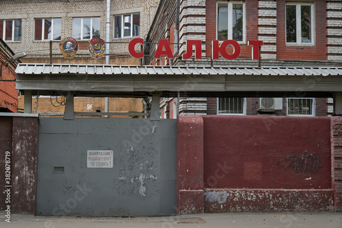 Factory gate with an inscription in Russian: "Salute"