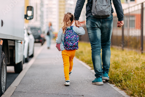 Obraz na płótnie Father and daughter going to school for the first time. Back to school after pandemic. w salonie
