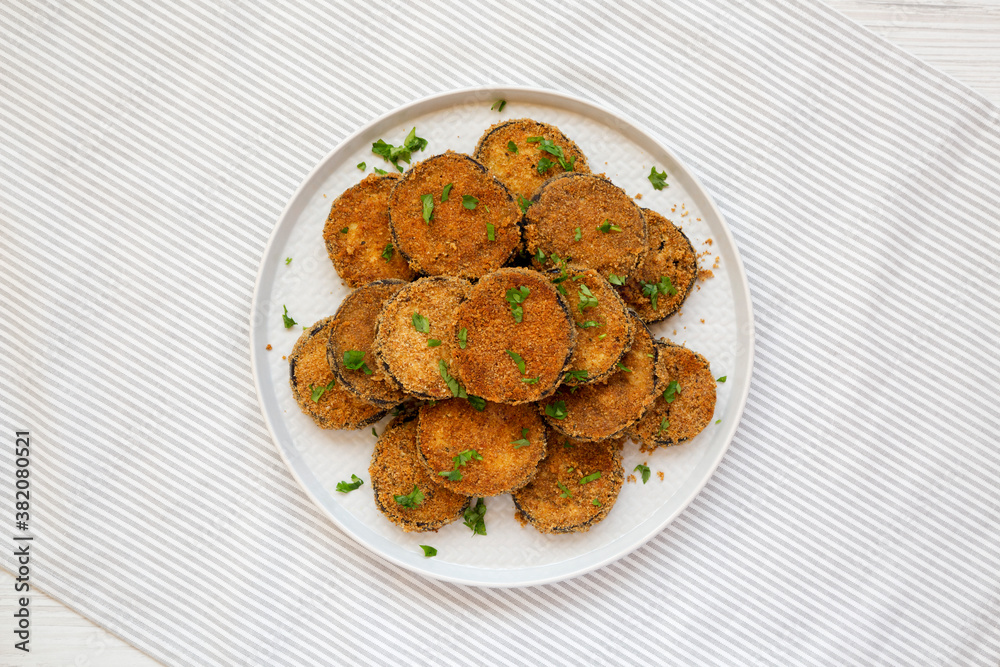 Homemade Garlic Parmesan Baked Eggplant on a plate, overhead view. Flat lay, top view, from above. Homemade Garlic Parmesan Baked Eggplant on a plate, overhead view. Flat lay, top view, from above.