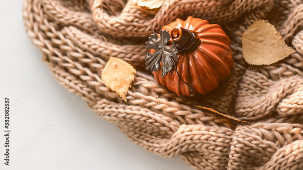 Obraz premium Autumn background with dry leaves, blue cup of coffee. Knitted background, pumpkins, October, November. Autumnal atmosphere. Autumn season.