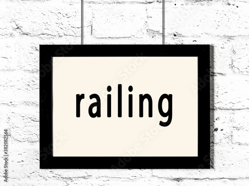 Black frame hanging on white brick wall with inscription railing photo