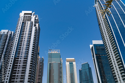 Low angle shot of glass skyscrapers of financial downtown of Dubai  UAE at sunny day. Modern low-angle view of the capital of the Emirate of Dubai. A trading international hub of Western Asia.