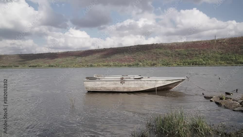 Old metal fishing boat moored in the shallow waters of the river Old metal fishing boat moored in the shallow waters of the river
