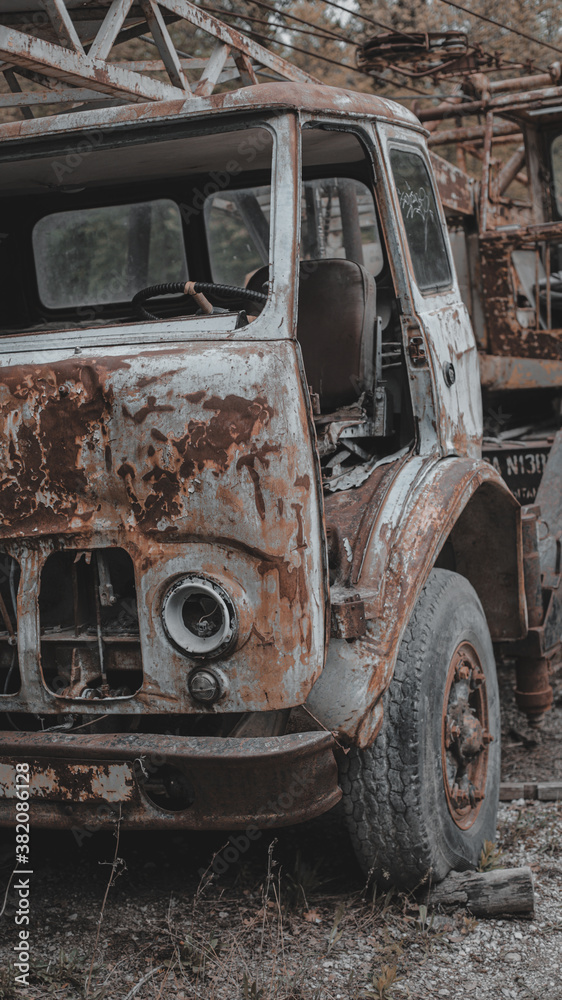 Old, rusty, abandoned truck crane in the woods. Old, rusty interior elements, controls and indicators. Vertical photo. Old, rusty, abandoned truck crane in the woods. Old, rusty interior elements, controls and indicators. Vertical photo.