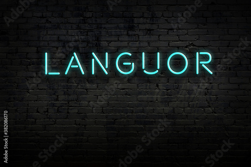 Neon sign. Word languor against brick wall. Night view photo