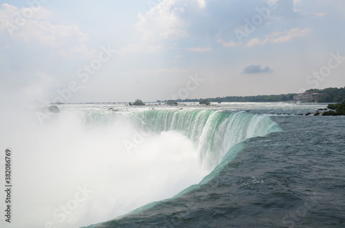 Closeup over the edge of the Canadian Niagara Falls in slightly cloudy weather