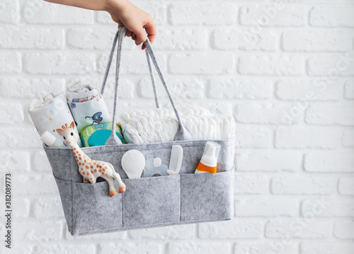 Mothers bag with toy, diapers and accessories on white background. photo