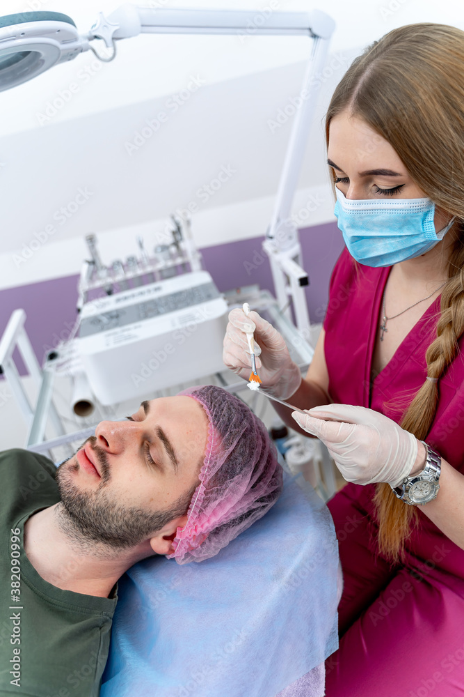 Man getting facial nourishing mask by beautician at spa salon. ?pa beauty treatment and skincare. Closeup. Man getting facial nourishing mask by beautician at spa salon. ?pa beauty treatment and skincare. Closeup.