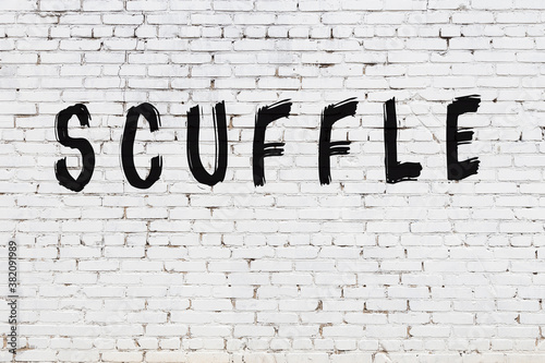 Inscription scuffle painted on white brick wall