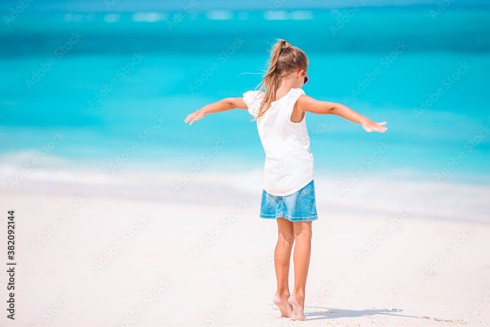 Adorable active little girl at beach during summer vacation Adorable active little girl at beach during summer vacation