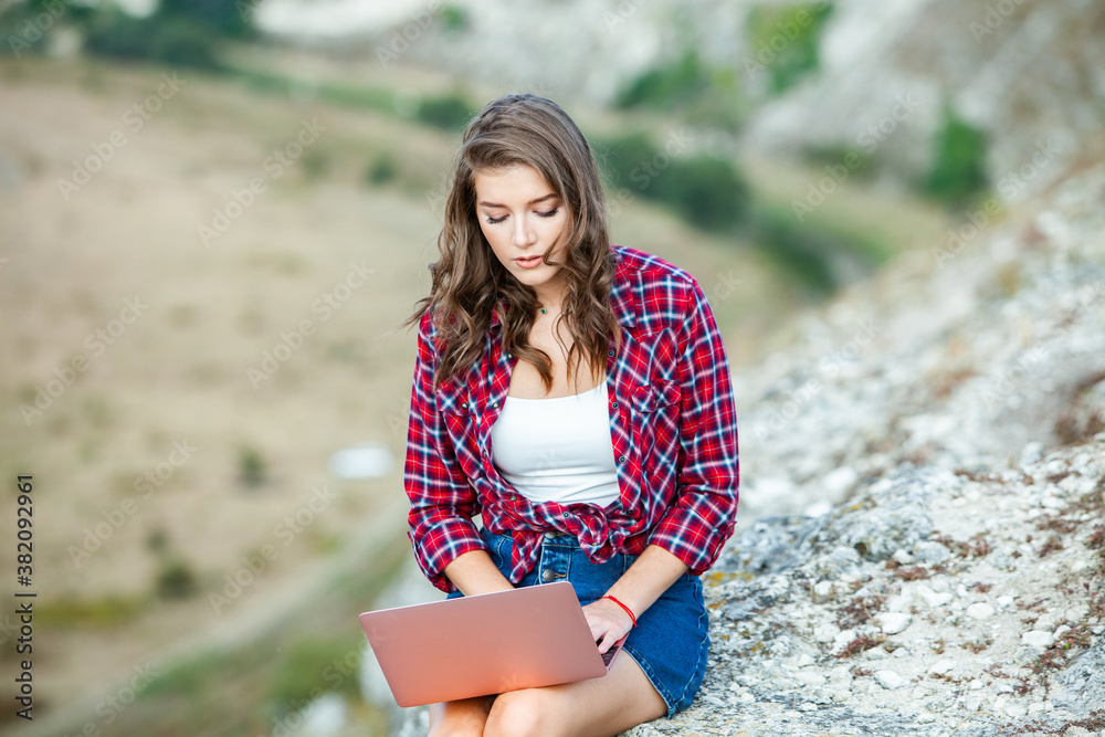 Office outdoors. Beautiful girl works on a laptop in the open air. woman freelancer. Freelance worker concept. Office outdoors. Beautiful girl works on a laptop in the open air. woman freelancer. Freelance worker concept.