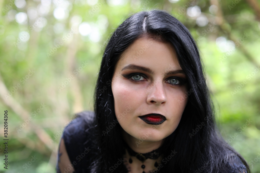 Portrait of spooky young woman with long black hair, blue eyes and dark makeup Portrait of spooky young woman with long black hair, blue eyes and dark makeup