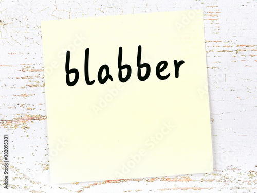 Fotobehang Yellow sticky note on wooden wall with handwritten word blabber