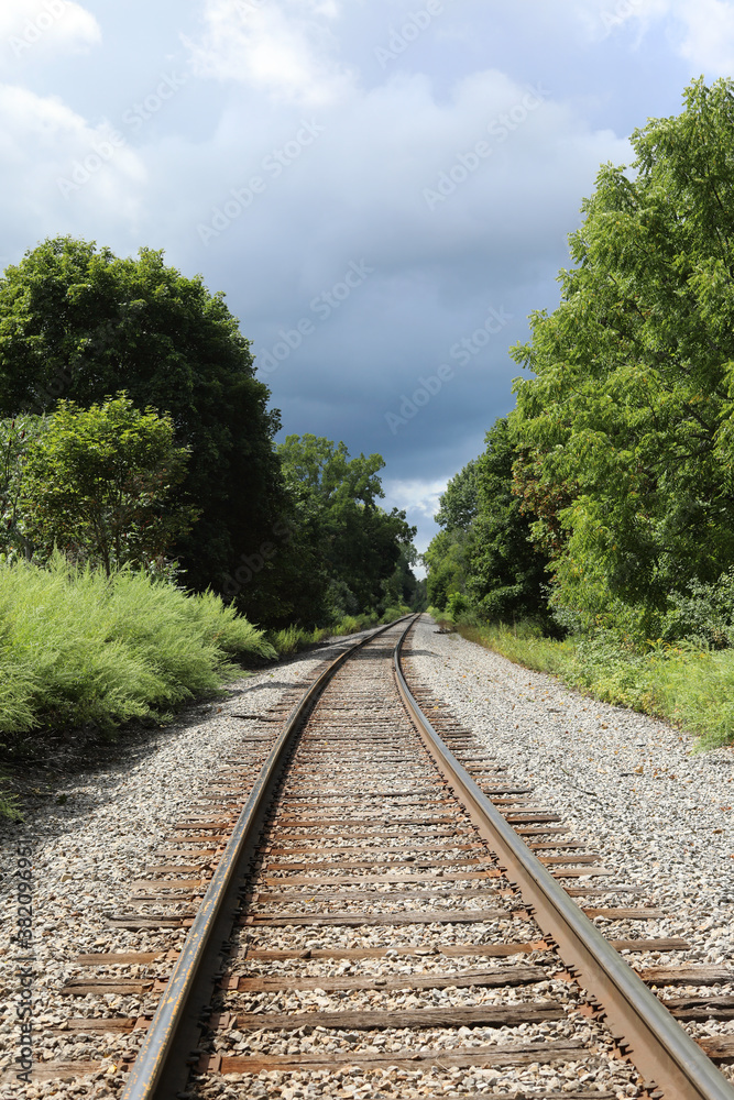 Fototapeta premium Railroad tracks heading into dark stormy sky