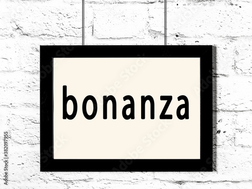 Black frame hanging on white brick wall with inscription bonanza photo